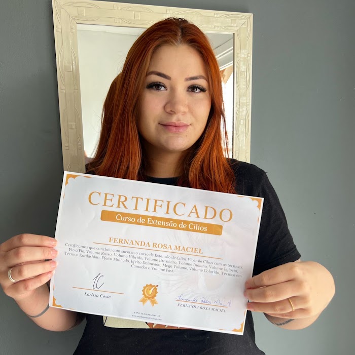 Aluna segurando o certificado do curso de extensão de cílios